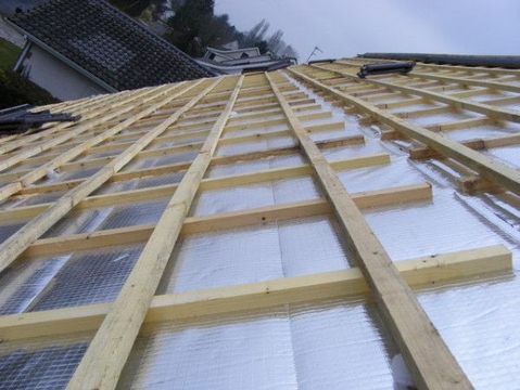 StarFlex®-Produkte - Isolierung des Hauses: Dach, Wände, Boden - Foto zeigend die Anbringung von StarFlex® Alufoil